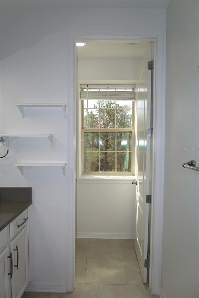 bathroom featuring tile patterned flooring, vanity, and baseboards