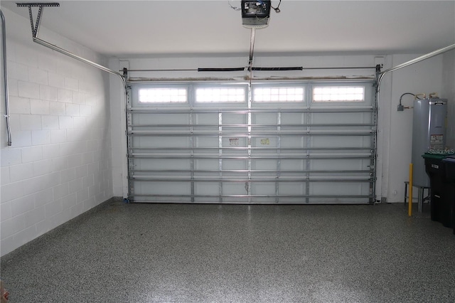 garage with concrete block wall, a garage door opener, and water heater