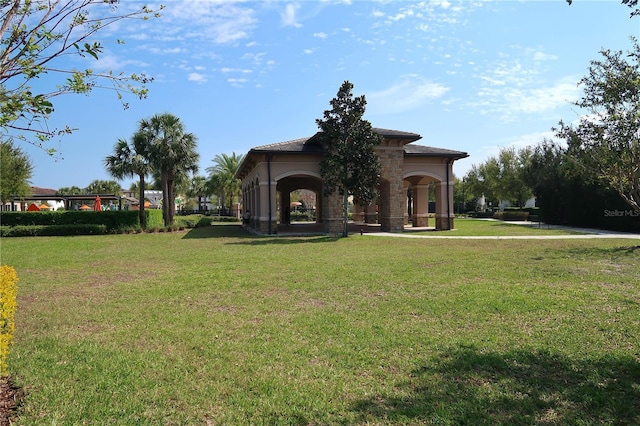 exterior space with stucco siding, stone siding, and a front yard