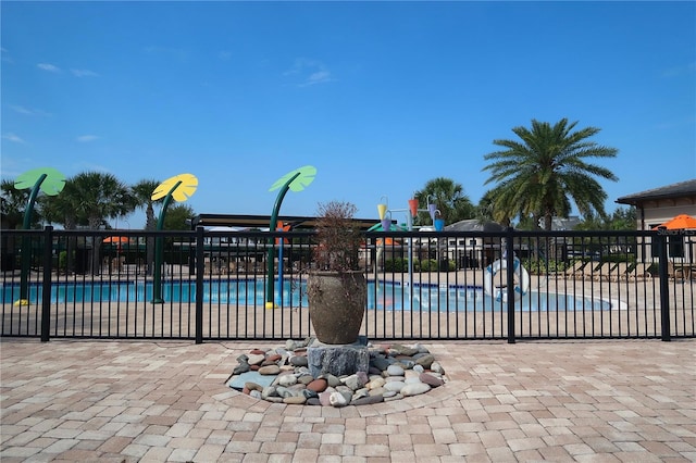 community pool with a patio and fence