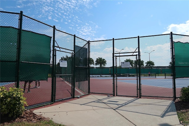 view of sport court with fence and a gate