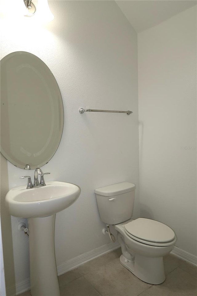 bathroom featuring tile patterned floors, toilet, and baseboards
