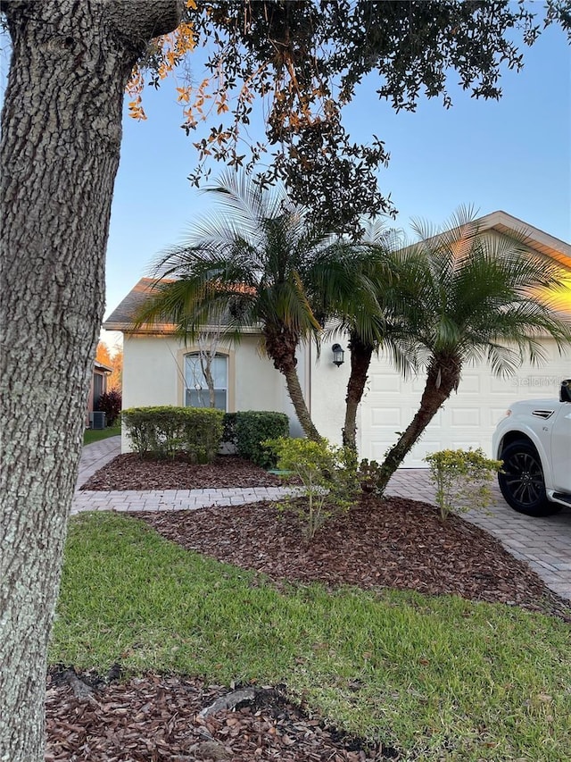 view of property exterior with driveway, an attached garage, and stucco siding