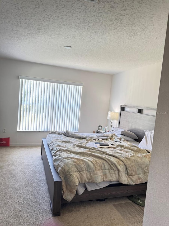 bedroom with a textured ceiling and carpet