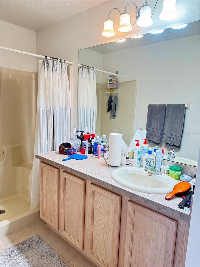 full bath with a textured ceiling, a shower stall, vanity, and tile patterned floors