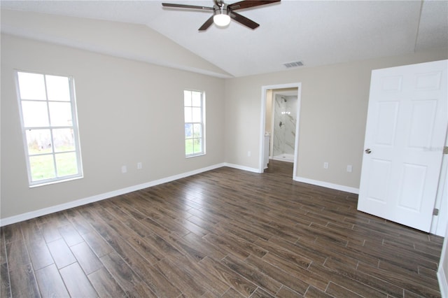 spare room featuring dark wood finished floors, visible vents, vaulted ceiling, ceiling fan, and baseboards