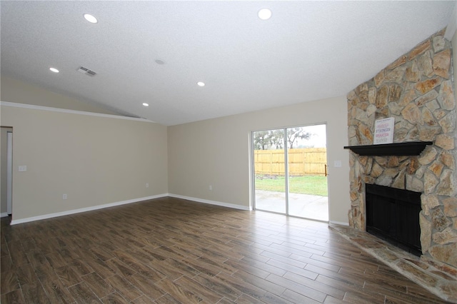 unfurnished living room featuring lofted ceiling, a fireplace, dark wood-style floors, and visible vents