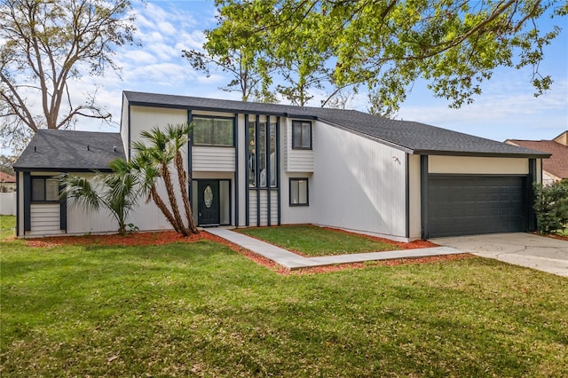 view of front of house with concrete driveway, a front lawn, and an attached garage