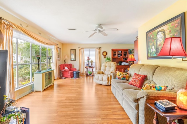 living area featuring light wood finished floors, visible vents, and a ceiling fan