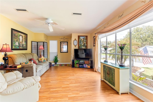 living room featuring visible vents, ceiling fan, light wood-style flooring, and baseboards