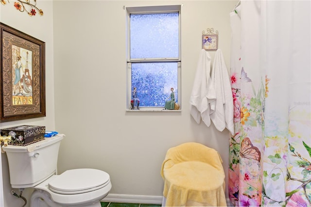 bathroom with toilet and baseboards