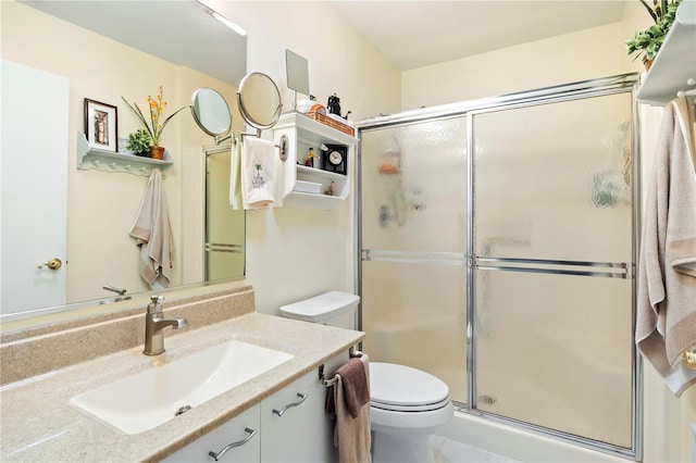 bathroom featuring toilet, a stall shower, and vanity