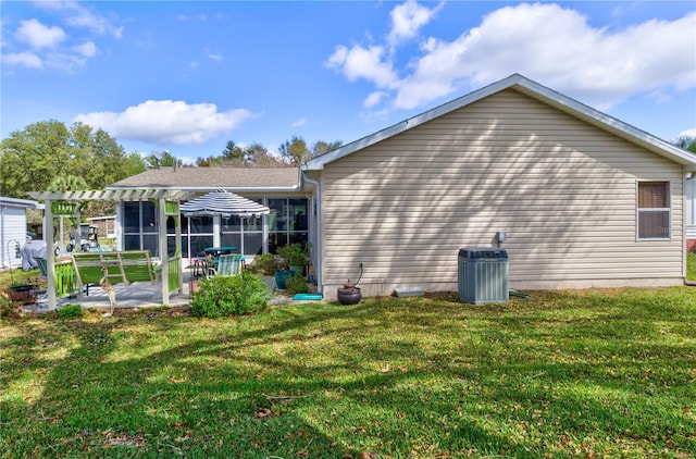 rear view of house with a lawn, central AC, and a patio