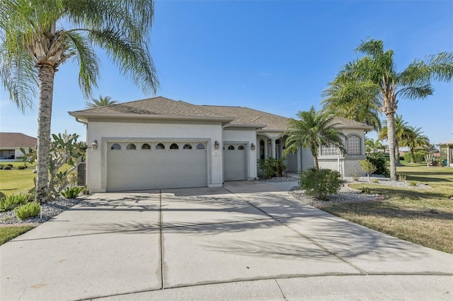 view of front of property with an attached garage, driveway, and stucco siding