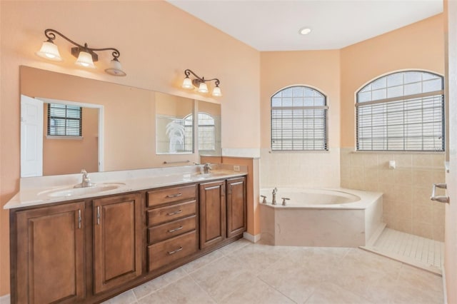 full bathroom featuring a garden tub, double vanity, tile patterned flooring, and a sink