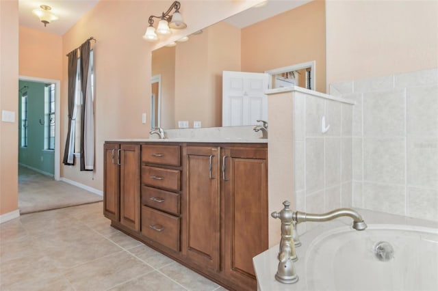 bathroom with double vanity, a sink, tile patterned flooring, baseboards, and a bath