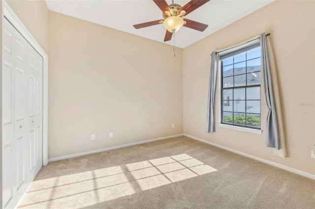 empty room featuring light carpet, ceiling fan, and baseboards