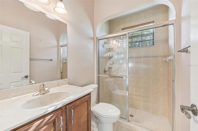 bathroom featuring tile patterned flooring, toilet, a shower stall, and vanity