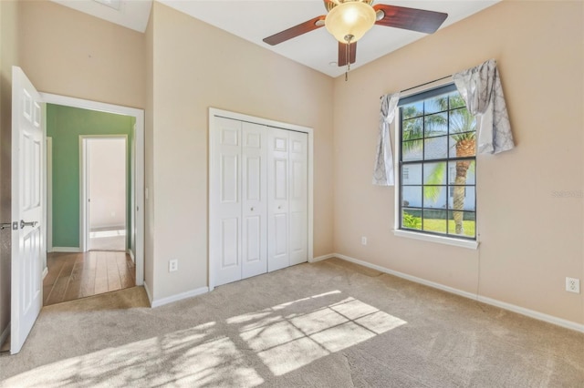 unfurnished bedroom with light carpet, multiple windows, baseboards, and a closet