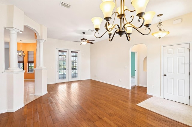 12018 SE 175th Loop, Summerfield, FL 34491 - unfurnished living room with a ceiling fan, wood-type flooring, a chandelier, arched walkways, and baseboards