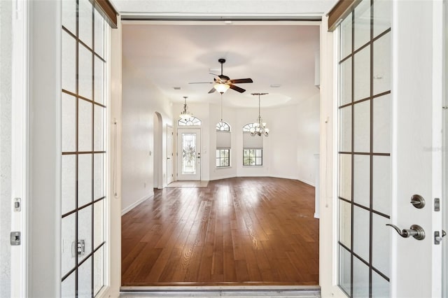 12018 SE 175th Loop, Summerfield, FL 34491 - unfurnished living room with a ceiling fan, hardwood / wood-style flooring, arched walkways, and baseboards