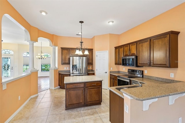 12018 SE 175th Loop, Summerfield, FL 34491 - kitchen featuring stainless steel appliances, decorative columns, arched walkways, a kitchen island, and a sink