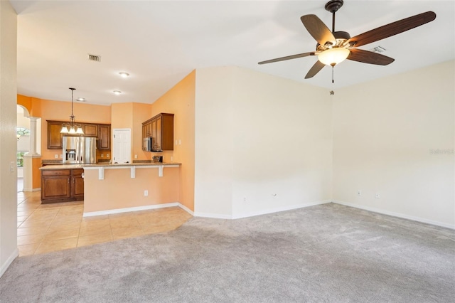 12018 SE 175th Loop, Summerfield, FL 34491 - unfurnished living room with ceiling fan, light carpet, baseboards, and a chandelier