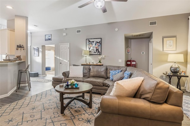 living area featuring light wood-style floors, ceiling fan, and visible vents