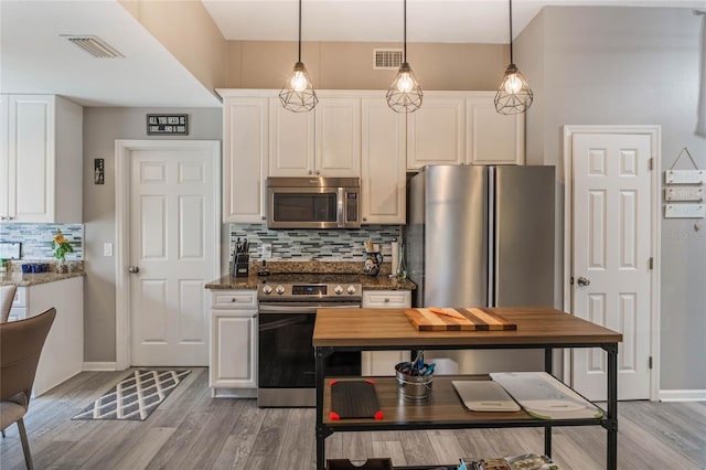 kitchen featuring stainless steel appliances, visible vents, decorative backsplash, white cabinets, and light wood-type flooring