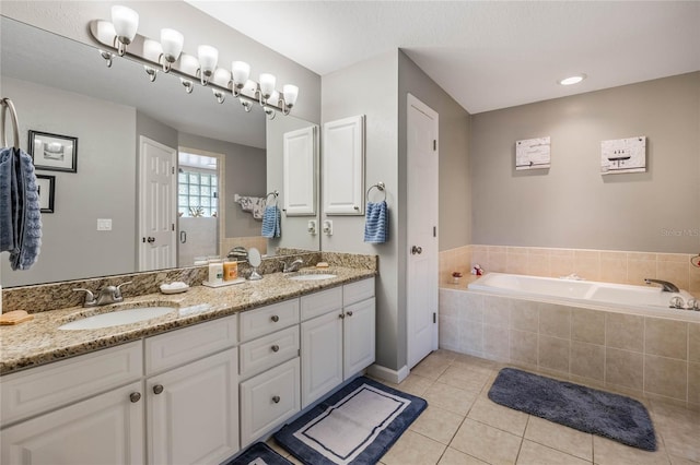 full bathroom featuring double vanity, a sink, a bath, and tile patterned floors