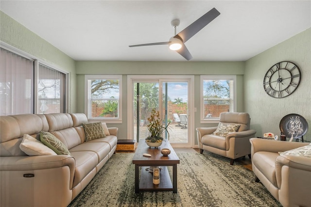 living area featuring a textured wall, wood finished floors, and a wealth of natural light