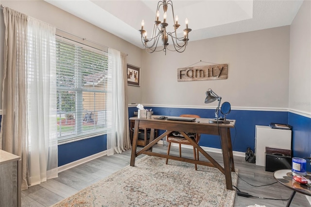 office with baseboards, a chandelier, a raised ceiling, and wood finished floors