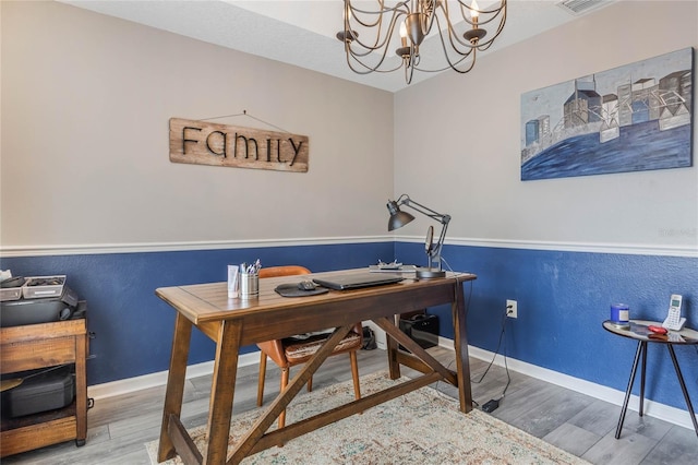 office space featuring an inviting chandelier, baseboards, and wood finished floors