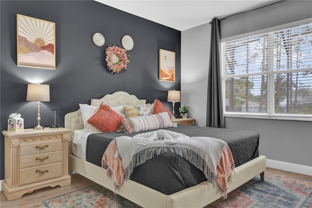 bedroom with baseboards and wood finished floors