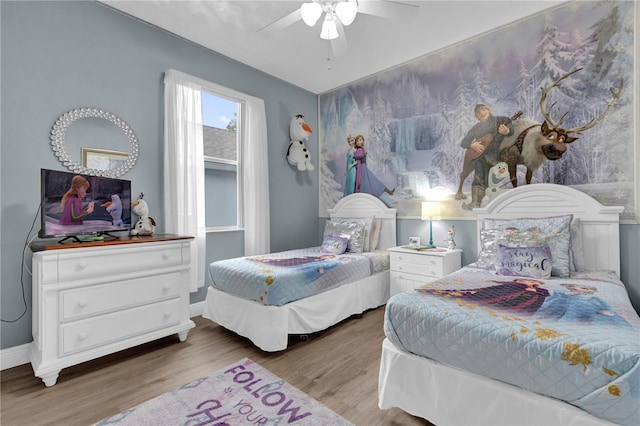 bedroom featuring a ceiling fan, baseboards, and wood finished floors