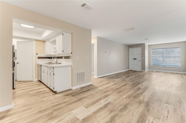 kitchen featuring white cabinetry, visible vents, open shelves, and a sink