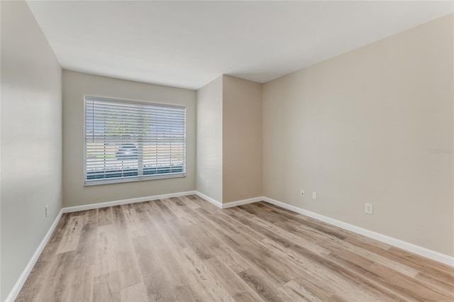 unfurnished room featuring light wood-type flooring and baseboards