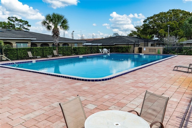 community pool featuring fence and a patio