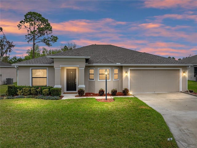 view of front of house featuring a garage, central AC, concrete driveway, stucco siding, and a front yard