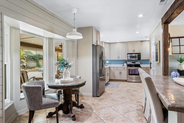 kitchen featuring decorative light fixtures, light tile patterned floors, recessed lighting, light countertops, and appliances with stainless steel finishes