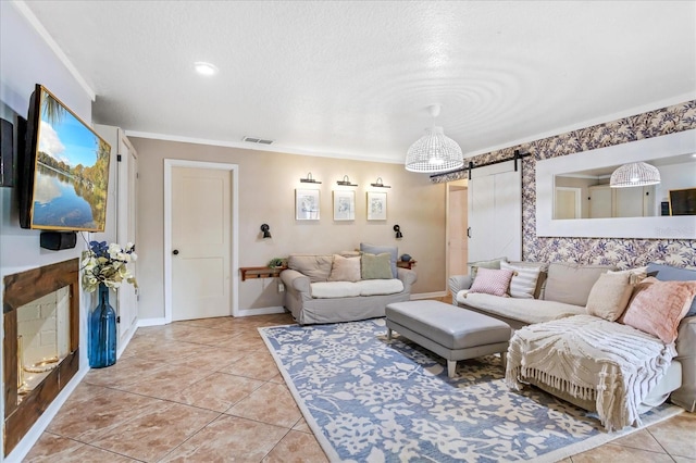 living area featuring light tile patterned flooring, visible vents, baseboards, and a barn door