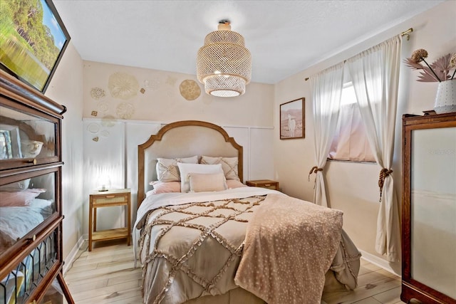 bedroom with a notable chandelier and light wood finished floors