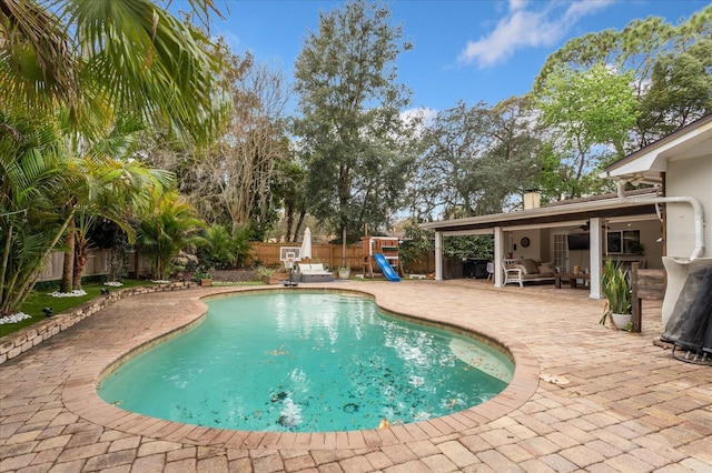 view of pool with a fenced in pool, a ceiling fan, a patio, a fenced backyard, and a playground