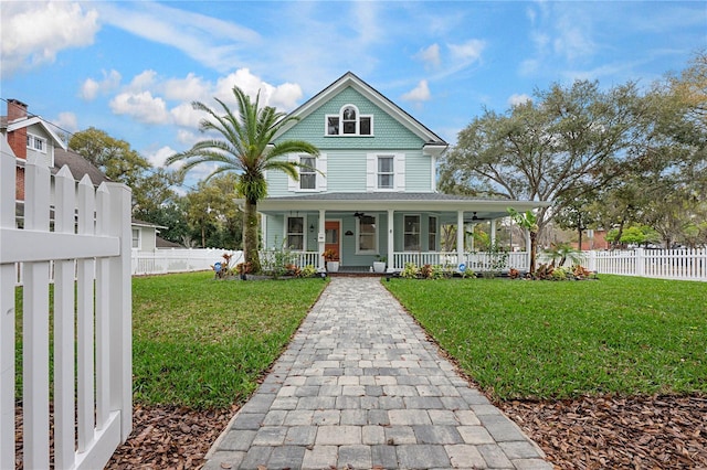 view of front of property with covered porch, a front lawn, and fence private yard