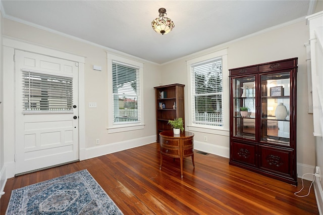 entrance foyer with visible vents, baseboards, dark wood finished floors, and ornamental molding