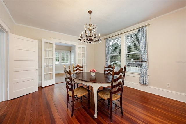 dining room featuring baseboards, a chandelier, dark wood finished floors, and crown molding