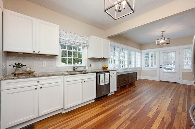 kitchen featuring dishwasher, decorative light fixtures, stone counters, white cabinetry, and a sink