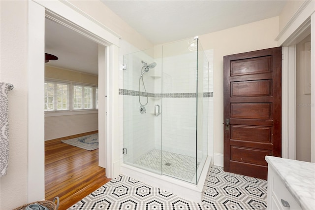 full bathroom with a shower stall, vanity, and wood finished floors