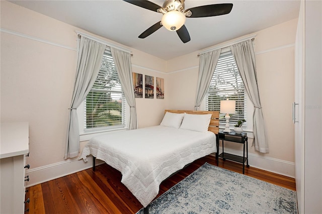 bedroom with dark wood-style flooring, ceiling fan, and baseboards