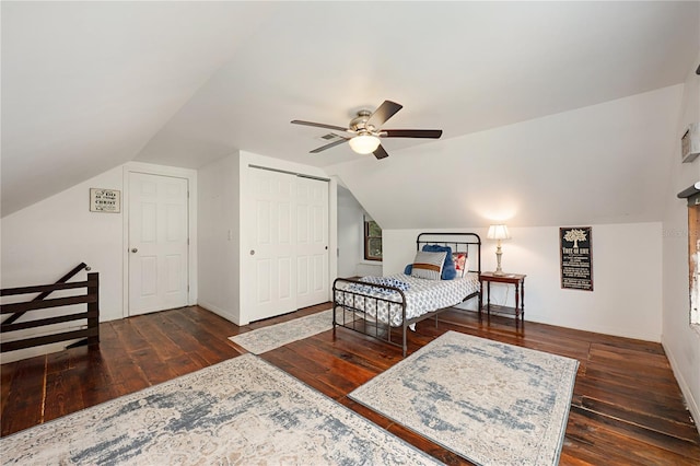 bedroom with a ceiling fan, baseboards, vaulted ceiling, a closet, and dark wood finished floors